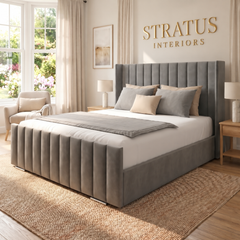Milan grey upholstered bed with vertical panels and gold Stratus Interiors wall lettering
